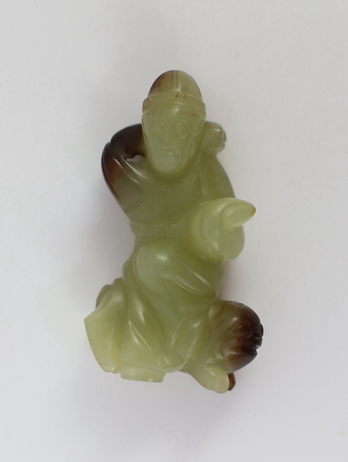 A Chinese yellow and brown jade figure of a man seated on a creature, 19th century, 4.3cm high